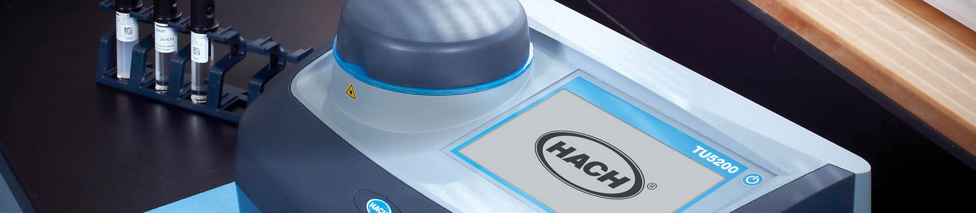 Image of lab benchtop with vials and a Hach TU5200 Turbidimeter